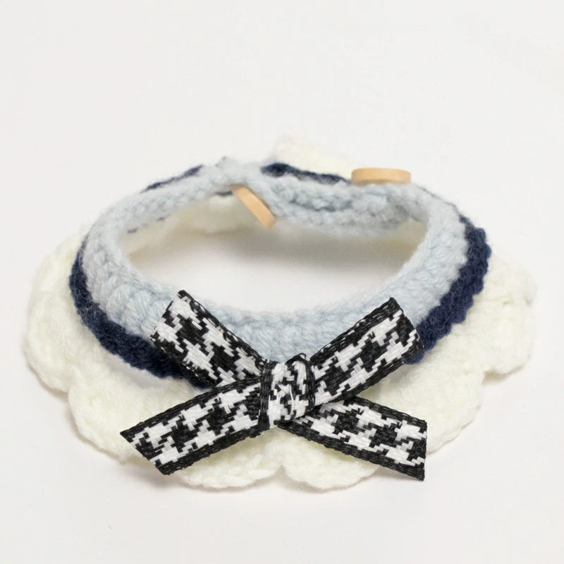 Handmade blue crochet cat collar made from soft yarn, featuring a decorative ribbon.