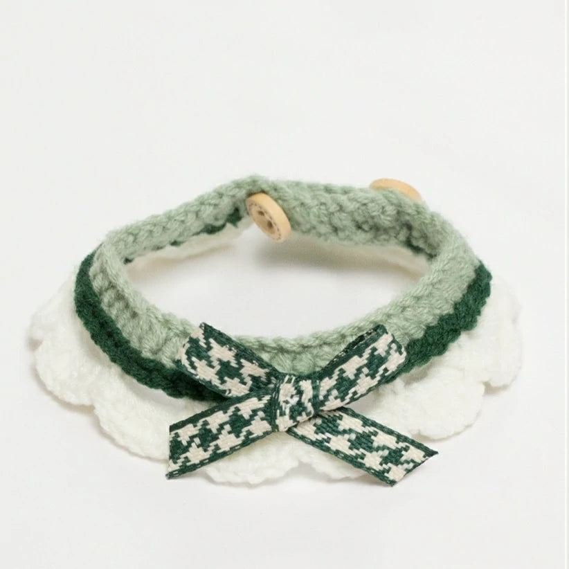 Handmade green crochet cat collar made from soft yarn, featuring a decorative ribbon.