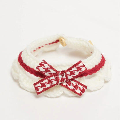 Handmade red crochet cat collar made from soft yarn, featuring a decorative ribbon.