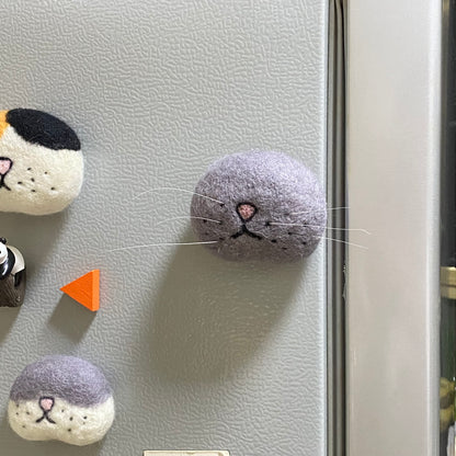 Handcrafted gray wool felt magnet shaped like a cat paw, perfect for decorating fridges or metal surfaces. Soft texture and charming design for cat lovers.