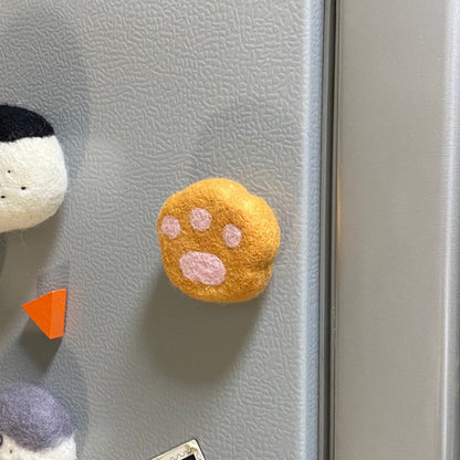 Handmade wool felt fridge magnet shaped like an orange tabby cat paw, adding a cozy, personal touch for cat lovers.