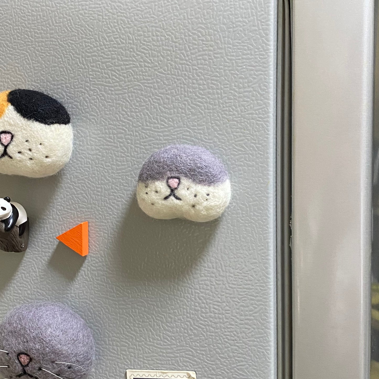 Cat whisker collector magnet made from wool felt, perfect for preserving your cat’s fallen whiskers as a keepsake on your fridge.